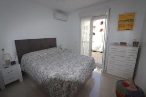 a bedroom with a bed and a dresser and a window at Torrevieja Spectacular Townhouse in Torrevieja