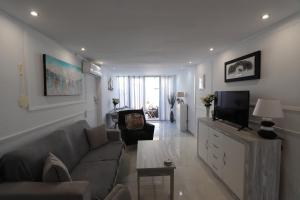 a living room with a couch and a tv at Torrevieja Spectacular Townhouse in Torrevieja