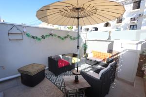 a patio with a table and an umbrella at Torrevieja Spectacular Townhouse in Torrevieja