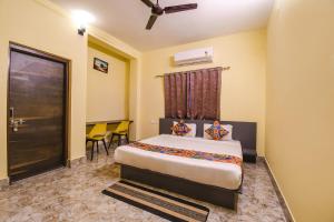 a bedroom with a bed in a room with a door at FabHotel Airport Residency I in Khandagiri