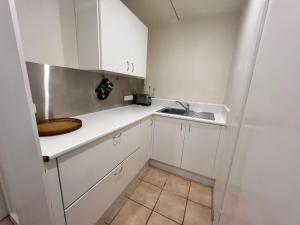 a small kitchen with white cabinets and a sink at Vista Bliss in Sandy Bay
