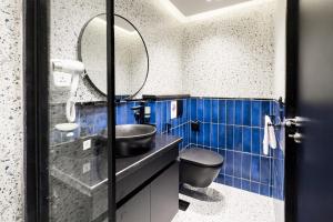 a blue tiled bathroom with a sink and a mirror at The 2 BDR Sapphire Condo K 5 min to CAI Airport in Cairo