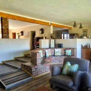 a living room with a brick fireplace and a chair at The Fat Mulberry Guest Farm in Fouriesburg +159 photos