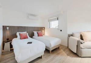 a bedroom with two beds and a couch and a chair at Appart Hotel Neostelia in Annecy