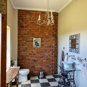 a bathroom with a brick wall and a sink at The Fat Mulberry Guest Farm in Fouriesburg +159 photos