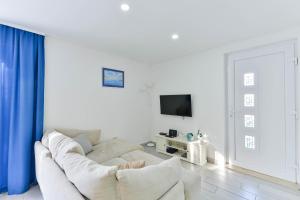 sala de estar blanca con sofá blanco y TV en Villa Anna with pool, Zadar County, en Vinjerac