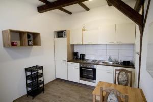 a kitchen with white cabinets and a wooden table at NEU! FeWo Märchenstube in Alsfeld