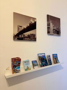 een plank met boeken en foto's aan een muur bij Luna Marie in Palermo