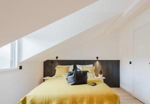 a bedroom with a yellow bed with a black headboard at Appart Hotel Neostelia in Annecy