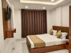 a bedroom with a bed and a window with curtains at Hotel Shiv in Indore +29 photos