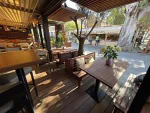 a wooden deck with a wooden table and benches at L'Oustaou De Porquerolles in Porquerolles
