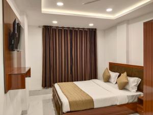 a hotel room with a bed and a window at Hotel Shiv in Indore