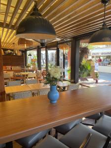 a table with a vase of flowers on it in a restaurant at L'Oustaou De Porquerolles in Porquerolles