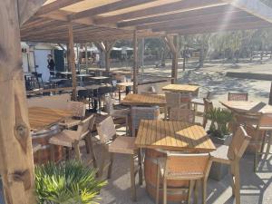an outdoor restaurant with tables and chairs and a pavilion at L'Oustaou De Porquerolles in Porquerolles +11 photos