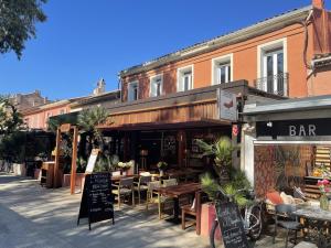 a restaurant with tables and chairs in front of a building at L'Oustaou De Porquerolles in Porquerolles