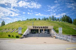 a train station with a hill in the background at Tehvandi Hotell in Otepää