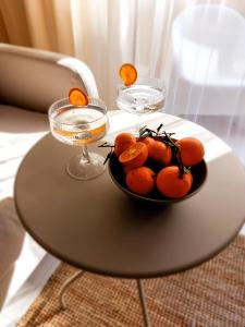 una ciotola di arance su un tavolo con due bicchieri di Apartamento La Palmera a Torrevieja