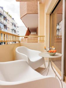balcone con tavolo e sedia bianca di Apartamento La Palmera a Torrevieja