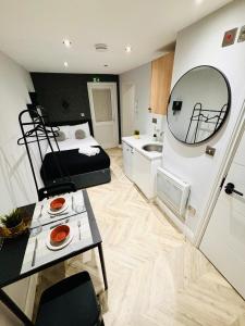 a bedroom with a bed and a sink and a mirror at Heathrow airport studios in West Drayton