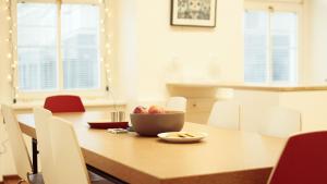 a dining room table with a bowl of fruit on it at Hostel Folks in Bratislava