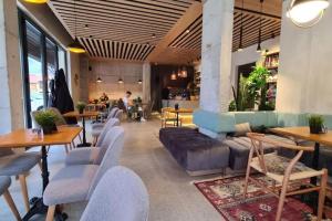 a restaurant with tables and couches in a room at Studio 2 Modern Mountain 2 in Kolašin