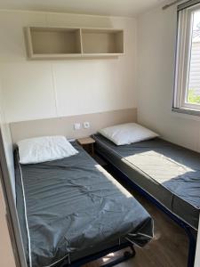 拉特斯Mobil home 55 -8 personnes的一间带窗户的小房间里有两张床