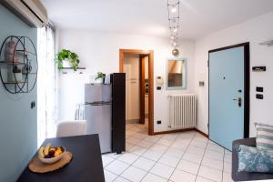 a living room with a table and a refrigerator at Casa Margot in Asti