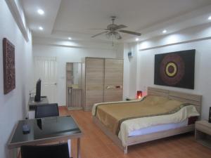 1 dormitorio con cama, escritorio y mesa en DAO Studio Apartments, en Patong Beach