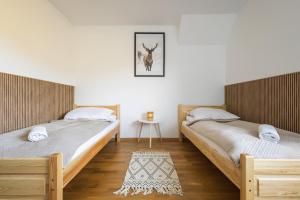 two twin beds in a room with a table at Apartament Widokowy HELLO TATRY - Basen & Sauna Koscielisko in Kościelisko +32 photos