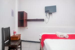 a bedroom with a bed and a tv on the wall at RedDoorz at Mayang Garini 2 Borobudur in Magelang