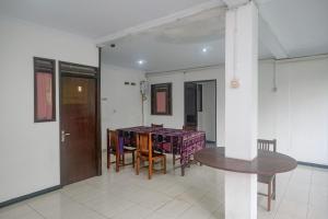 a dining room with a table and chairs in a room at RedDoorz at Mayang Garini 2 Borobudur in Magelang