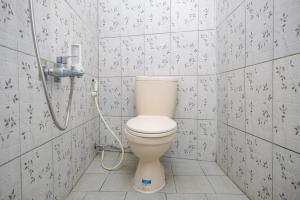 a bathroom with a toilet and a shower at RedDoorz at Mayang Garini 2 Borobudur in Magelang +34 photos
