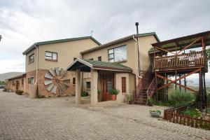 a house with a windmill on the side of it at The Fat Mulberry Guest Farm in Fouriesburg