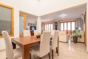 a dining room and living room with a table and chairs at Villa Mar y Tierra in La Cabaneta