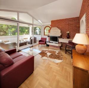 a living room with a red couch and a brick wall at Villa Vulin Veruda in Pula