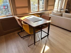 a table and chairs with a laptop on it in a room at Stylish independent Studio S1, City Centre Dordrecht in Dordrecht