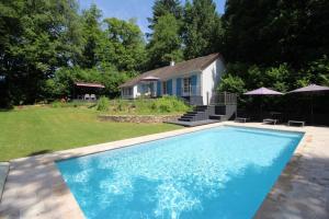 a swimming pool in front of a house at Le clos des chênes in Thouron