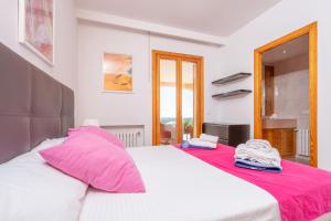 a bedroom with a large white bed with pink pillows at Villa Mar y Tierra in La Cabaneta +23 photos