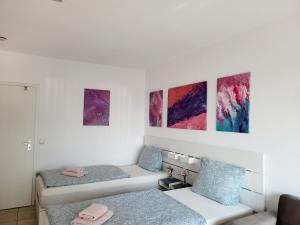 Una habitación con dos camas y cuadros en la pared. en 2 Zimmer für 3-4 Person , Klima, Parkplatz, en Mülheim an der Ruhr