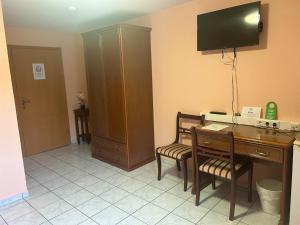 ザールブリュッケンにあるMikroapartments Klarenthalのデスク、壁掛けテレビが備わる客室です。