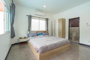 une chambre avec un grand lit et une salle de bain dans l'établissement Pool Villa 3 Bedrooms, Closeby Patong, Chic and Quiet, à Ban Thung Thong
