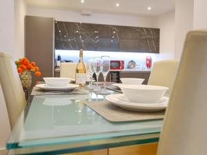 a dining table with a bottle of wine and glasses at Pass the Keys Mill Conversion Flat Mins from City Bars Shops in Manchester