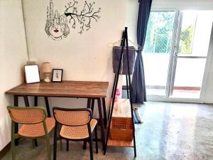 a room with a table and chairs and a lamp at WAKE UP @Lanta Hotel : Cafe in Ko Lanta