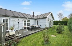 FrørupNice Home In Frørup With Wifi的庭院内带桌子的甲板的房子