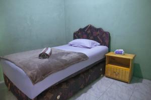 SaonekRaja Ampat Sandy Guesthouse的一间带床和床头柜的小卧室