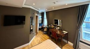 a living room with a desk and a television on a wall at Halvard Hotel in Douglas