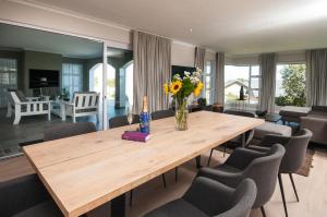 a dining room with a wooden table and chairs at Windstar Retreat Knysna in Knysna