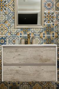 a bathroom with a mirror and a tv on a tiled wall at Windstar Retreat Knysna in Knysna