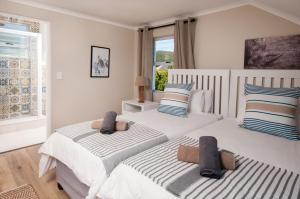 a bedroom with two beds and a window at Windstar Retreat Knysna in Knysna