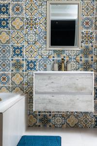 a bathroom with a tv on a tiled wall at Windstar Retreat Knysna in Knysna +30 photos